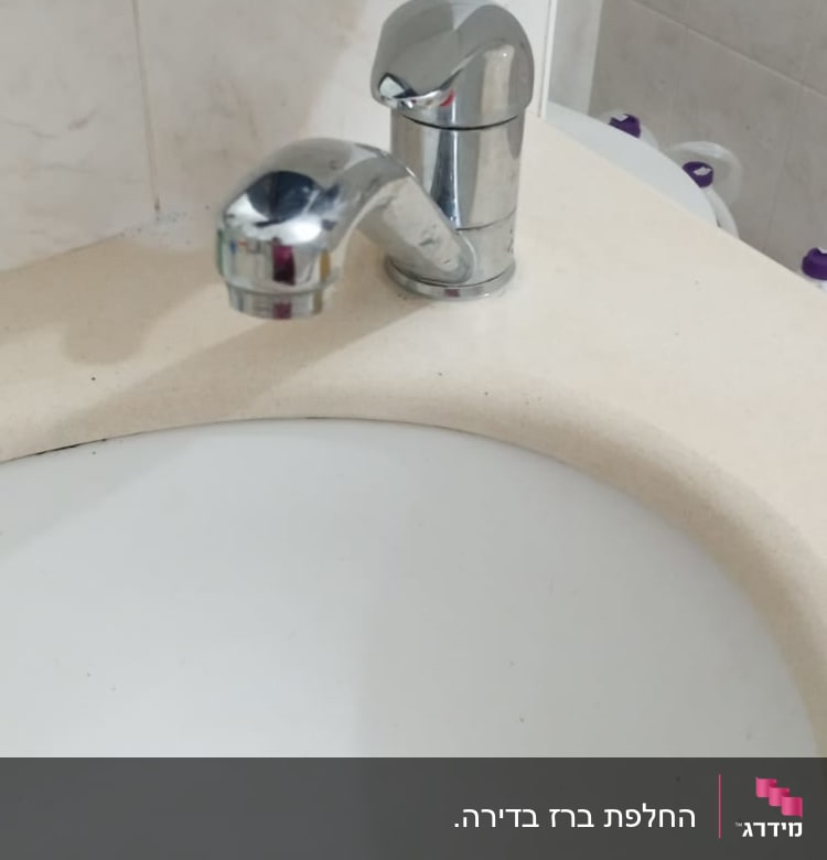 ברז כרום מותקן על כיור אמבטיה לבן